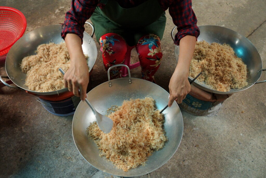 “Người làm đang đảo chà bông thủ công trên bếp than tại Phượng Chà Bông”.